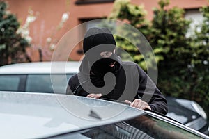 Car thief entering the vehicle and stealing a car.