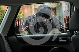 Car thief looking through car window