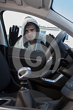 Car Thief Looking Through Window Of Vehicle