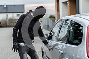 Car thief pulls the handle of a car.