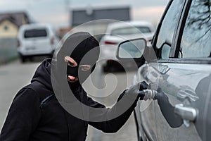 Car thief pulls the handle of a car.