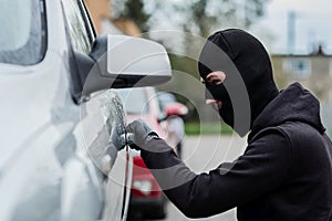 Car thief pulls the handle of a car.