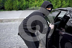 Car thief steal car breaking door criminal job burglar Hijacks  Auto thief black balaclava hoodie trying  break into vehicle