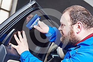 Car tinting. Automobile mechanic technician applying foil