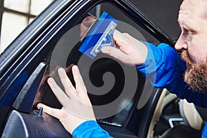 Car tinting. Automobile mechanic technician applying foil