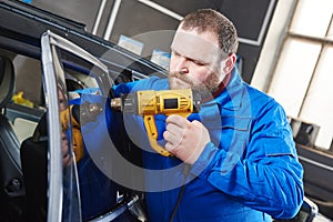 Car tinting. Automobile mechanic technician applying foil