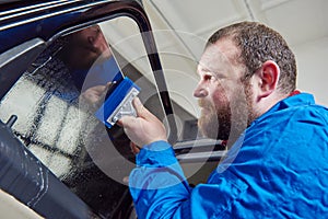 Car tinting. Automobile mechanic technician applying foil