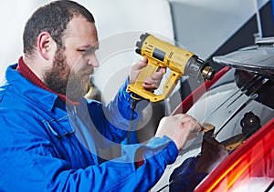 Car tinting. Automobile mechanic technician applying foil