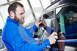 Car tinting. Automobile mechanic technician applying foil