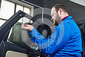 Car tinting. Automobile mechanic technician applying foil