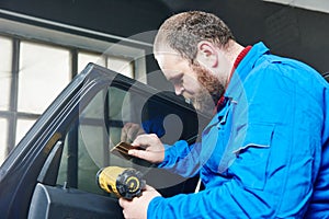 Car tinting. Automobile mechanic technician applying foil