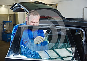 Car tinting. Automobile mechanic technician applying foil