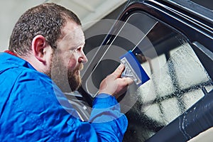 Car tinting. Automobile mechanic technician applying foil