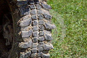 Car tire with a deep tread for off-road driving is dirty.