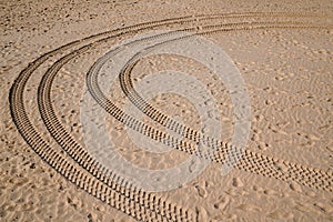 Car tire footprint and wheel track on sand in desert beach on fine sand of desert dune