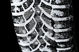 The car tire in the snow close up. Car tracks on the snow. Traces of the car in the snow. Winter tires. Tyres covered with snow at