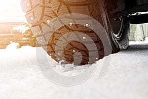 Car tire in the snow close up. Car tracks on the snow. Traces of the car in the snow. Winter tires. Tyres covered with snow at