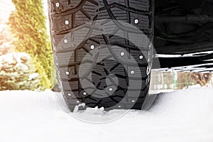 Car tire in the snow close up. Car tracks on the snow. Traces of the car in the snow. Winter tires. Tyres covered with snow at