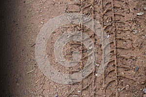 A car tire trace on dark red laterite. Shown deep mark of the car tire.