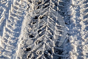 Car tire tracks. Snowy and icy road, dangerous and unsafe. Winter morning