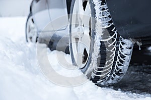 Car tire in winter on the road covered with snow, close up picture