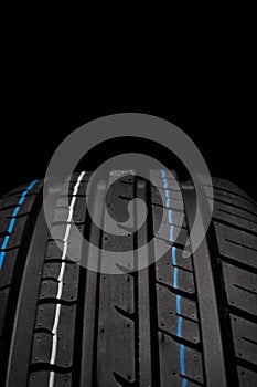 Car tires on black background, closeup of tread, selective focus. photo