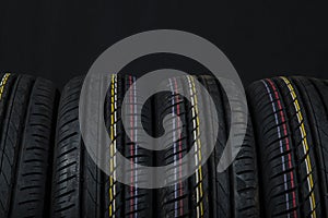 Car tires on a black background. Tire and disk stores