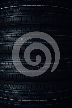 Car tires on black background. Tires stacked in a row.