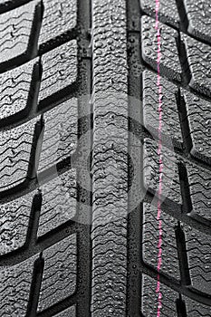 Car tires close-up Winter wheel profile structure with waterdrops