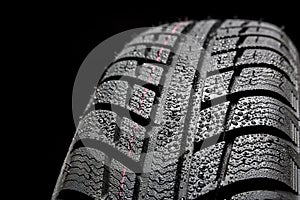 Car tires close-up Winter wheel profile structure with waterdrops on blue black background