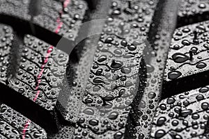 Car tires close-up Winter wheel profile structure with waterdrops on blue black background