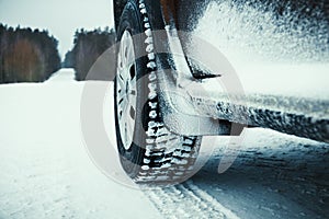 Car tires covered with snow on winter road.