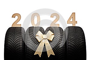 Car tires, new year 2024 tyres, winter wheels golden christmas ribbon