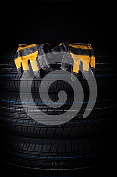 Car tires with rubber gloves on black background. Safety concept. Copy space.