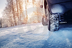 Car tires on winter road covered with snow