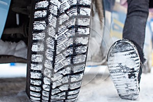 Car tires on the winter road are covered with snow