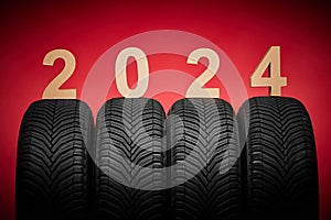 Car tires, winter wheels, isolated new tyres, happy new year 2024 on red background