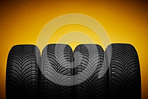 Car tires, winter wheels isolated on yellow background