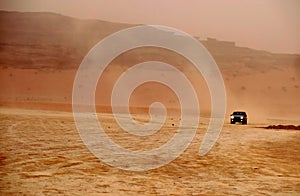 Car of tourists in search of adventures in the desert