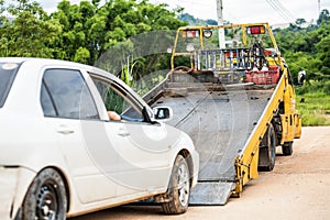 Car tow in front of accident car on the road