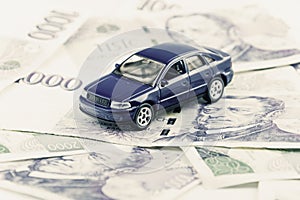 A car toy on banknotes as a concept of buying or renting a car