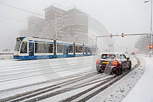 Car at traffic lights at intersection in Amsterdam during a heavy snow storm in the Netherlands