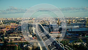 Car traffic on modern multilevel highway bridge over river water in big city