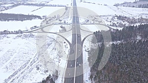 Car traffic on road junction at winter highway aerial view