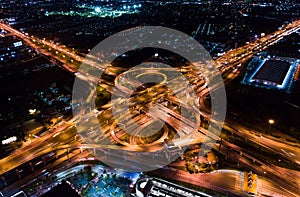 Car traffic transport on multiple lane highway or winding road expressway in Asia city at night, drone aerial view