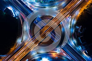 Car traffic transportation above intersection road in Bangkok city night, aerial view cityscape of advanced innovation, financial