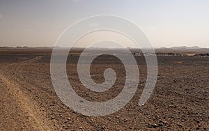 Car trail on the gravel desert landscape