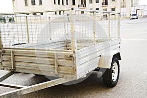 Car trailer. car trailer with two wheel axle, Loaded silver car trailer at the Storage Place in a countryside