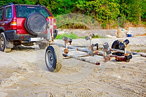 Car with trailer parked on the sandy beach