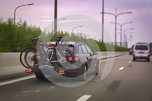 Car transports bicycles on a rack on highway in early morning